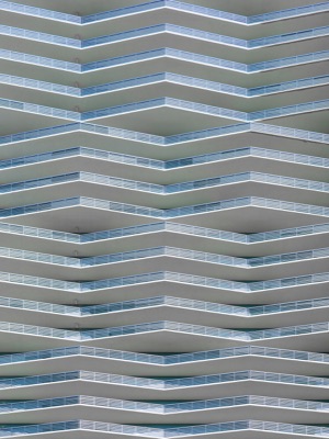 Architectural detail of the Icon Bay building by Arquitectonica, featuring a repeating geometric pattern of zigzagging balconies with glass railings.